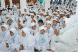 Ketua Pusat Kerja Gugus  Kecamatan Banjarbaru Utara Siti Rusdah memimpin doa bersama 800 anak PAUD  se Kecamatan Banjarbaru Utara di Aula Madinah Asrama Haji Embarkasi Banjarmasin, Senin (12/2).   Manasik haji usian dini adalah sebagian dari pendidikan karakter bagi anak-anak PAUD sehigga mereka dapat mengerti tata cara pelaksanaan haji bagi umat muslim yang mampu.Foto Antaranews Kalsel/hms/f)