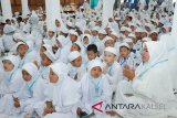 Ketua Pusat Kerja Gugus Kecamatan Banjarbaru Utara Siti Rusdah memimpin doa bersama 800 anak PAUD se-Kecamatan Banjarbaru Utara di Aula Madinah Asrama Haji Embarkasi Banjarmasin, Senin (12/2). Manasik haji usia dini adalah sebagian dari pendidikan karakter bagi anak-anak PAUD sehingga mereka dapat mengerti tata cara pelaksanaan haji bagi umat muslim yang mampu.Foto Antaranews Kalsel/hms/f)