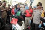 Kapolda Kalbar, Irjen Pol Didi Haryono (kanan) bersama Direktur Reskrimum Polda Kalbar, Kombes Pol Arif Rachman (dua kanan) mendampingi Tri Astuti (tengah) yang menerima kembali motornya yang berhasil ditemukan petugas kepolisian saat gelar hasil ungkap kasus Operasi Panah Kapuas 2018 di Mapolda Kalbar, Jumat (9/2). Terhitung dari 22 Januari hingga 7 Februari 2018, jajaran Dit Reskrimsus Polda Kalbar dan Sat Reskrim Polresta Pontianak berhasil mengungkap 228 kasus pencurian (biasa, berat, dengan kekerasan) serta menangkap 258 tersangka saat melaksanakan Operasi Panah Kapuas 2018. ANTARA FOTO/Jessica Helena Wuysang/18