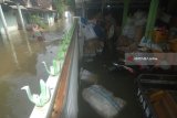 Warga melintas di depan rumah yang terendam banjir di Desa Blimbing, Gudo, Jombang, Jawa Timur, Kamis  (22/2). Berdasarkan data Badan Penanggulangan Bencana Daerah (BPBD) Jombang, setidaknya terdapat 9 Kecamatan dan ratusan rumah yang terdampak banjir yakni di Kecamatan Bareng, Mojowarno, Ngoro, Gudo, Mojoagung, Sumobito, Jombang, Diwek, dan Peterongan. Antara Jatim/Syaiful Arif/zk/18