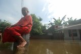 Warga duduk diatas pagar jalan yang terendam air banjir di Desa Blimbing, Gudo, Jombang, Jawa Timur, Kamis  (22/2). Berdasarkan data Badan Penanggulangan Bencana Daerah (BPBD) Jombang, setidaknya terdapat 9 Kecamatan dan ratusan rumah yang terdampak banjir yakni di Kecamatan Bareng, Mojowarno, Ngoro, Gudo, Mojoagung, Sumobito, Jombang, Diwek, dan Peterongan. Antara jatim/Syaiful Arif/zk/18