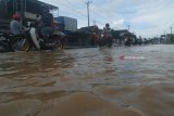 Kendaraan bermotor melintas di Jalan Raya Jombang-Surabaya yang terendam banjir tepatnya di Mojoagung, Jombang, Jawa Timu, Kamis (22/2). Jalan raya teresebut terendam air luapan air sungai gunting, sehingga arus lalu lintas dialihkan melalui jalur lingkar atau ringroad Mojoagung. Antara Jatim/Syaiful Arif/zk/18