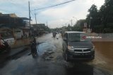 Kendaraan bermotor melintas di Jalan Raya Jombang-Surabaya yang terendam banjir tepatnya di Mojoagung, Jombang, Jawa Timu, Kamis (22/2). Jalan raya teresebut terendam air luapan air sungai gunting, sehingga arus lalu lintas dialihkan melalui jalur lingkar atau ringroad Mojoagung. Antara Jatim/Syaiful Arif/zk/18