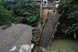 Warga berada di sekitar jembatan Cikaroya yang putus di desa Gumulung Lebak, Beber, Cirebon, Jawa Barat, Minggu (25/2). Jembatan penghubung dua kecamatan yaitu kecamatan Beber dan Greged tersebut putus akibat terjangan air saat banjir terjadi pada Sabtu (24/2) lalu.