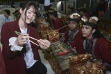 Mahasiswa asal Jepang mengajarkan cara menggunakan sumpit kepada mahasiswa Stikom Bali saat melakukan kunjungan di Denpasar, Bali, Kamis (1/2). Kunjungan mahasiswa gabungan tiga universitas asal Kumamoto, Jepang tersebut untuk melakukan pertukaran informasi dan berbagi pengalaman dalam bidang pendidikan dan kebudayaan dengan mahasiswa Indonesia. ANTARA FOTO/Fikri Yusuf/wdy/2018.