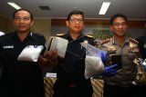 Kepala Kantor Bea Cukai Bandara Soetta Erwin Situmorang (tengah) bersama Kapolres Bandara Kombes Ahmad Yosep Gunawan dan Kasubdit III Dir IV Narkoba Mabes Polri Kombes Pol Turman Siregar menunjukkan barang bukti sabu yang dikemas dalam kopi saset dan pembalut wanita saat rilis kasus di Bea Cukai Bandara Soekarno Hatta, Tangerang, Banten, Selasa (27/2). Bea Cukai Bandara Soetta bekerjasama dengan Polres Bandara dan Dir IV Narkoba Mabes Polri berhasil menggagalkan masuknya barang haram sabu seberat 3 kg lebih yang dibawa oleh warga negara Malaysia dan Thailand. 