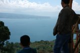 Pengunjung menikmati Danau Toba di Puncak Simarjarunjung