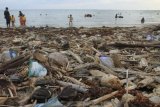 Sejumlah warga beraktivitas di kawasan pantai yang dipenuhi sampah di Desa Lhok Bubon, Kecamatan Samatiga, Aceh Barat, Aceh, Minggu (18/2). Berbagai jenis sampah seperti sampah plastik dan kayu yang terseret gelombang dan terdampar di bibir pantai tersebut mengakibatkan aktivitas warga dan wisatawan terganggu. (ANTARA FOTO/Syifa Yulinnas/ama/18)
