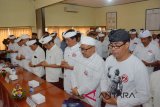 Calon Gubernur Bali nomor urut 1 Wayan Koster (kelima kanan) dan Calon Wakil Gubernur Bali nomor urut 2 Ketut Sudikerta (ketiga kanan) bersama para pendukung melakukan persembahyangan bersama di kantor KPU Bali, Kamis (15/2). Persembahyangan bersama itu dilakukan bersamaan dengan pembukaan jadwal kampanye untuk memohon keselamatan sekaligus pemimpin yang baik untuk masyarakat Bali. ANTARA FOTO/Wira Suryantala/wdy/2018.