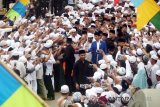 Warga sambut dengan antusias saat rombongan Presiden RI Joko Widodo hadir pada acara Haul ke-13 guru sekumpul, KH. Muhammad Zaini Abdul Ghani (Guru Izai) Martapura, Minggu, (25/3). Foto:Antaranews Kalsel/Herry Murdy/M.