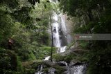 Pengunjung berada di area air terjun Dolo, Kediri, Jawa Timur, Rabu (21/3). Air terjun setinggi 125 meter di lereng gunung Wilis itu pada hari biasa sepi pengunjung karena hanya bisa ditempuh dengan berjalan kaki menuruni ribuan anak tangga. Antara Jatim/Prasetia Fauzani/zk/18