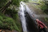 Pengunjung berada di area air terjun Dolo, Kediri, Jawa Timur, Rabu (21/3). Air terjun setinggi 125 meter di lereng gunung Wilis itu pada hari biasa sepi pengunjung karena hanya bisa ditempuh dengan berjalan kaki menuruni ribuan anak tangga. Antara Jatim/Prasetia Fauzani/zk/18
