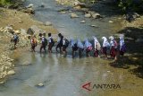 Siswa sekolah dasar menyeberangi Sungai Ciwadas Dawa di Kampung Ciakar, Kabupaten Ciamis, Jawa Barat, Selasa (6/3). Belum diperbaiki dan tidak layak dilaluinya jembatan gantung penghubung antara Desa Pesawahan dengan Desa Kalijaya menyebabkan sebagian warga setempat harus menyeberangi sungai untuk mobilitias keseharian mereka. ANTARA JABAR/Adeng Bustomi/agr/18