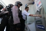 Polisi mengawasi pihak keamanan bank memeriksa mesin Anjungan Tunai Mandiri (ATM) di Bank BRI, Jalan Rajawali, Surabaya, Jawa Timur, Selasa (20/3). Peningkatan patroli dengan melakukan pemeriksaan mesin ATM di sejumlah bank yang dilakukan oleh Unit Raimas Sat Sabhara Polrestabes Surabaya itu untuk mengantisipasi kejahatan 'skimming'. Antara Jatim/Didik Suhartono/zk/18