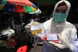 Petugas dari Dinas Kesehatan Kota Surabaya menunjukkan dua bungkus makanan yang diambil dari pedagang untuk diuji kehigienisannya di laboratorium, di depan SDN Pacar Keling I, Surabaya, Jawa Timur, Senin (26/3). Pemeriksaan makanan dan minuman di sejumlah sekolah itu bertujuan untuk mengantisipasi adanya makanan dan minuman tidak layak konsumsi atau berbahaya beredar di lingkungan sekolah. Antara Jatim/Didik Suhartono/zk/18