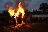 Sejumlah orang melihat ogoh-ogoh sebelum dibakar di depan Pura Sanggha Bhuwana Lanud Iswahjudi Magetan, Jawa Timur, Jumat (16/3). Pembakaran ogoh-ogoh sebagai simbol pemusnahan segala hal buruk dan kejahatan di dunia dilakukan umat Hindu menjelang Nyepi. Antara Jatim/Foto/Siswowidodo/zk/18