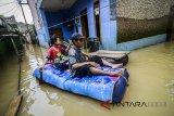 Warga dengan menggunakan perahu karet melintasi banjir di Kampung Bojong Asih, Desa Dayeuhkolot, Kabupaten  Bandung, Jawa Barat, Selasa (6/3). Banjir yang merendam ribuan rumah di delapan kecamatan Kabupaten Bandung akibat meluapnya Sungai Citarum sejak Jumat (23/2), hingga saat ini belum surut. ANTARA JABAR/Raisan Al Farisi/agr/18