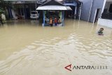 Warga melintasi genangan banjir yang merendam desa Wanakaya, Gunung Jati, Cirebon, Jawa Barat, Senin (12/3). Akibat hujan deras sejak dua hari lalu membuat banjir meluas hingga tujuh kecamatan di Cirebon. ANTARA JABAR/Dedhez Anggara/agr/18.