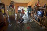 Warga menonton acara di televisi sambil menunggu surut air banjir di Desa Tanjungsari, Kabupaten Tasikmalaya, Jawa Barat, Senin (12/3). Akibat luapan anak sungai Citanduy, Cikidang ditambah intensitas curah hujan yang tinggi mengakibatkan 220 rumah terendam banjir setinggi 60 cm di empat kampung diantaranya Kampung Bojongsoban, Bojongwaru, Hegarsari dan Cicalung. ANTARA JABAR/Adeng Bustomi/agr/18 