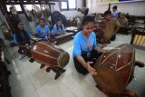 Pelajar dari sekolah Pluakdaeng Pittayakom School Rayong, Thailand dan pelajar SMP Muhammadiyah 5 Surabaya memainkan gamelan saat mengiringi pementasan wayang kulit 