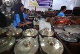 Pelajar dari sekolah Pluakdaeng Pittayakom School Rayong, Thailand dan pelajar SMP Muhammadiyah 5 Surabaya memainkan gamelan saat mengiringi pementasan wayang kulit 