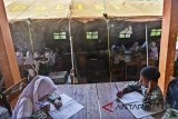 Siswa Madrasah Ibtidaiyah (MI) Pasawahan mengikuti kegiatan belajar mengajar di dalam tenda darurat di Dusun Ciakar, Kabupaten Ciamis, Jawa Barat, Rabu (7/3). Para siswa terpaksa belajar di dalam tenda darurat karena dua ruang kelas dan satu ruang guru roboh akibat pergerakan tanah. ANTARA JABAR/Adeng Bustomi/agr/18.