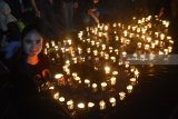 Seorang duta 'Earth Hour' Surabaya membawa lilin ketika memperingati 'Earth Hour 2018 di Surabaya, Jawa Tiimur, Sabtu (24/3) malam. Aksi mematikan lampu tersebut dilakukan sebagai bentuk kepedulian terhadap kondisi bumi sekaligus kampanye untuk menghemat pemakaian listrik. Antara Jatim/M Risyal Hidayat/zk/18