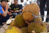 Sejumlah orang makan durian saat digelar Festival Durian di halaman Stasiun Kereta Api Madiun, Jawa Timur, Jumat (30/3). PT Kereta Api Indonesia (KAI) memberikan kesempatan makan durian gratis bagi pengguna aplikasi KAI access pada Festival Durian yang digelar selama dua hari hingga Sabtu (31/3). Antara Jatim/Foto/Siswowidodo/zk/18