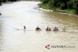 Sejumlah pengendara roda dua memanfaatkan jasa perahu rakit untuk menyeberangi Sungai Cisadane di Rumpin, Bogor, Jawa Barat, Senin (12/3). Akibat rusaknya jembatan yang menghubungkan akses jalan utama Rumpin-Ciseeng, sejumlah warga memanfaatkan jasa penyeberangan sepeda motor dengan perahu rakit atau getek dengan tarif Rp10.000 untuk sekali melintas. ANTARA JABAR/Yulius Satria Wijaya/agr/18.