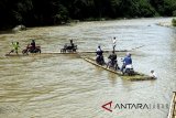 Sejumlah pengendara roda dua memanfaatkan jasa perahu rakit untuk menyeberangi Sungai Cisadane di Rumpin, Bogor, Jawa Barat, Senin (12/3). Akibat rusaknya jembatan yang menghubungkan akses jalan utama Rumpin-Ciseeng, sejumlah warga memanfaatkan jasa penyeberangan sepeda motor dengan perahu rakit atau getek dengan tarif Rp10.000 untuk sekali melintas. ANTARA JABAR/Yulius Satria Wijaya/agr/18.