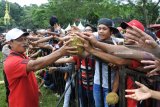 Petugas membagikan gunungan durian yang dipajang di Lapangan Sumberjambe, Jember, Jawa Timur, Sabtu (31/3). Puluhan gunungan durian merupakan rangkaian dari kegiatan sedekah bumi yang digelar warga setempat sebagai wujud syukur atas hasil bumi yang melimpah. Antara Jatim/Seno/zk/18.