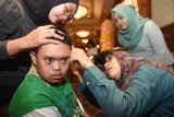 Seorang dokter memeriksa kebersihan telinga penyandang Down Syndrome pada puncak peringatan Hari Down Syndrome Dunia 2018 di Surabaya, Jawa Timur, Rabu (21/3). Peringatan yang diikuti oleh ratusan penderita Down Syndrome dengan bertemakan 