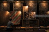 Pekerja menata kain batik yang dipajang di salah satu stan pada pameran Hinggil Batik Fest 2018 di salah satu pusat perbelanjaan di Surabaya, Jawa Timur, Kamis (1/3). Pameran yang memamerkan berbagai macam batik dan kerajinan dari berbagai daerah itu berlangsung sampai 4 Maret 2018. Antara Jatim/Didik Suhartono/zk/18