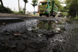 Truk melintas di jalan anternatif penghubung Jombang dengan Kediri di Desa Plemahan, Kediri, Jawa Timur, Rabu (7/3). Jalan rusak puluhan kilometer dari kecamatan Kunjang hingga kecamatan Pagu itu biasa digunakan sebagai pengalih arus lalu lintas apabila terjadi kemacetan di simpang Mengkreng. Antara Jatim/Prasetia Fauzani/zk/18