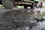 Truk melintas di jalan anternatif penghubung Jombang dengan Kediri di Desa Plemahan, Kediri, Jawa Timur, Rabu (7/3). Jalan rusak puluhan kilometer dari kecamatan Kunjang hingga kecamatan Pagu itu biasa digunakan sebagai pengalih arus lalu lintas apabila terjadi kemacetan di simpang Mengkreng. Antara Jatim/Prasetia Fauzani/zk/18