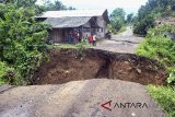 Warga melihat jembatan yang putus akibat longsor di Desa Mekarsari, Cikalong Kulon, Kabupaten Cianjur, Jawa Barat, Sabtu (10/3). Meluapnya sungai Cipinang akibat intensitas hujan yang tinggi di wilayah Cianjur pada Jum'at (9/3) sore, mengakibatkan jembatan putus dan menutup akses warga menuju jalan utama Cianjur-Jonggol. ANTARA JABAR/Arif Firmansyah/agr/18