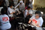 Calon Gubernur Jawa Timur, Khofifah Indar Parawansa (tengah) membatik kain saat mengunjungi industri rumah batik di kawasan Sukodono, Jawa Timur, Jumat (23/3). Calon Gubernur Jawa Timur bernomor urut satu tersebut selain berusaha meraih simpati massa juga mendengarkan keluhan secara langsung perajin batik. Antara Jatim/Umarul Faruq/zk/18