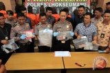 Kapolres Lhokseumawe, AKBP Ari Lasta (tengah), Wakapolres Kompol Imam Asfali (ketiga kiri) dan Kasat Reskrim AKP Budi Nasuha Waruwu (kedua kanan) menunjukkan barang bukti bersama sejumlah pekerja seks komersil (PSK) online saat rilis kasus di Polres Lhokseumawe, Aceh, Selasa (27/3/2018). Kepolisian setempat membongkar prostitusi online dan mengamankan empat pria hidung belang dan lima wanita diduga pelaku prostitusi online, yang kesemuanya dijerat dengan pasal 25 ayat (2) jo pasal 23 ayat (2) jo pasal 6 qanun (peraturan daerah) syariat Islam nomor 6/2014 tentang hukum jinayat dengan hukuman cambuk. (ANTARA/Rahmad).