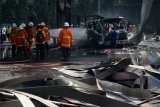 Petugas pemadam kebakaran melakukan pembasahan Stasiun Pengisian Bahan Bakar Umum (SPBU) yang terbakar di kawasan Surabaya Industrial Estate Rungkut (SIER), Brebek, Sidoarjo, Jawa Timur, Kamis (8/3). Kebakaran tersebut disebabkan percikan api saat proses pengisian truk yang membawa tabung gas.  Antara Jatim/Umarul Faruq/zk/18