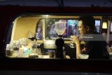 Barista meracik kopi di dalam mobil yang telah dimodifikasi menjadi kafe berjalan (food truck) pada acara 'Kediri Food Vaganza' di Kediri, Jawa Timur, Jumat (23/3) malam. Kegiatan yang menghadirkan 12 food truck tersebut guna mendorong perkembangan pelaku usaha makanan dan minuman tanpa tempat usaha menetap. Antara Jatim/Prasetia Fauzani/zk/18