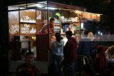 Pedagang menyiapkan pesanan di dalam mobil yang telah dimodifikasi menjadi warung makan berjalan (food truck) pada acara 'Kediri Food Vaganza' di Kediri, Jawa Timur, Jumat (23/3) malam. Kegiatan yang menghadirkan 12 food truck tersebut guna mendorong perkembangan pelaku usaha makanan dan minuman tanpa tempat usaha menetap. Antara Jatim/Prasetia Fauzani/zk/18