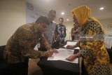 Pemimpin Divisi KPR dan KKB Bank BJB Agus Kurniawan (kedua kiri) menyaksikan proses penandatanganan kerja sama oleh GM Perum Perumnas Regional VI Ari Indrianto (kiri) di Surabaya, Jawa Timur, Kamis (8/3). Kerja sama tersebut guna memperluas jangkauan Bank BJB untuk pembiayaan serta kepemilikan rumah bagi masyarakat pada proyek perumahan Sentraland Residance dan D'Garden City yang berlokasi di Jawa Timur. Antara Jatim/Moch Asim/zk/18