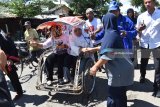 Calon Gubernur Jawa Timur nomor urut satu Khofifah Indar Parawansa menumpang becak (kanan) menyapa warga di kawasan pasar Sumoroto, Kauman saat melakukan rangkaian kampanye di Ponorogo, Jawa Timur, Minggu (11/3). Selain bertemu dengan pedagang dan warga pasar, Khofifah melakukan serangkaian kegiatan antara lain bertemu seniman Reog Ponorogo, mengunjungi pondok pesantren, perajin jenang, perajin reog, ziarah ke makam, kunjungan wisata ke Telaga Ngebel. Antara Jatim/Foto/Siswowidodo/zk/18