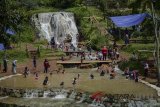 Wisatawan berenang di bawah air terjun kolam air panas Cipanas Nagrak, Lembang, Kabupaten Bandung Barat, Jumat (30/3). Wisata air panas yang berasal dari aliran belerang Gunung Tangkuban Perahu tersebut menjadi alternatif untuk mengisi liburan panjang Hari Raya Paskah di Kabupaten Bandung Barat. ANTARA JABAR/Raisan Al Farisi/agr/18