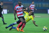 Pesepak bola Madura United (MU) Greg Nwokolo (kiri) berusaha melewati pesepak bola Barito Putra, Nazar Nurzaidin (kanan) dalam kompetisi Go-Jek  Liga 1 di Stadion Gelora Ratu Pamelingan (SGRP) Pamekasan, Jawa Timur,  Senin (26/3) malam. MU mengandaskan Barito dengan skor 3-1. Antara Jatim/Saiful Bahri/zk/18.