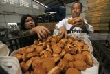 Kepala Balai Besar Pengawas Obat dan Makanan (BBPOM) Surabaya Sapari mengamankan barang bukti makanan ringan saat melakukan penggerebekan di pabrik makanan ringan di Jalan Nambangan, Surabaya, Jawa Timur, Senin (12/3). Sekitar 4.120 kardos (1 kardus isi 100 bungkus) makanan ringan Pia Bali yang diduga tidak memiliki ijin edar diamankan dan sejumlah mesin produksi turut disegel dalam penggerebekan tersebut. Antara Jatim/Didik Suhartono/zk/18