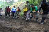 Sebuah alat berat membersihkan material longsor di Desa Curah Tatal, Arjasa, Situbondo, Jawa Timur, Sabtu (3/3). Petugas gabungan dan warga melakukan pembersihan material longsor di sebelas titik, yang menutup jalur utama penghubung antar empat dusun di Desa Curah Tatal. Antara Jatim/Seno/zk/18.