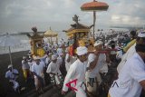 Umat Hindu membawa benda sakral pada puncak ritual Melasti menjelang Hari Raya Nyepi Tahun Saka 1940 di Pantai Purnama, Gianyar, Bali, Rabu (14/3). Ritual tahunan tersebut berlangsung selama tiga hari secara bergantian yang sebagian besar digelar di pantai, danau dan sungai di seluruh Bali untuk penyucian alam sehingga Hari Raya Nyepi dapat berjalan hening serta damai. Antaranews Bali/Nyoman Budhiana/2018.