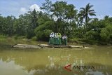 Pelajar menggunakan rakit bambu untuk menyeberang Sungai Ciputrahaji di Desa Sukasari, Kabupaten Ciamis, Jawa Barat, Rabu (7/3). Mereka terpaksa menggunakan rakit bambu karena tidak adanya jembatan penghubung Desa Sukasari dengan Desa Sindangrasa. ANTARA JABAR/Adeng Bustomi/agr/18.
