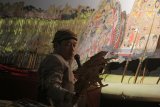 Dalang Ki Purbo Asmoro memainkan wayang saat acara Pergelaran Wayang Kulit Malam Prajurit di Makoarmatim, Surabaya, Jawa Timur, Jumat (2/3). Pergelaran wayang yang menceritakan lakon 